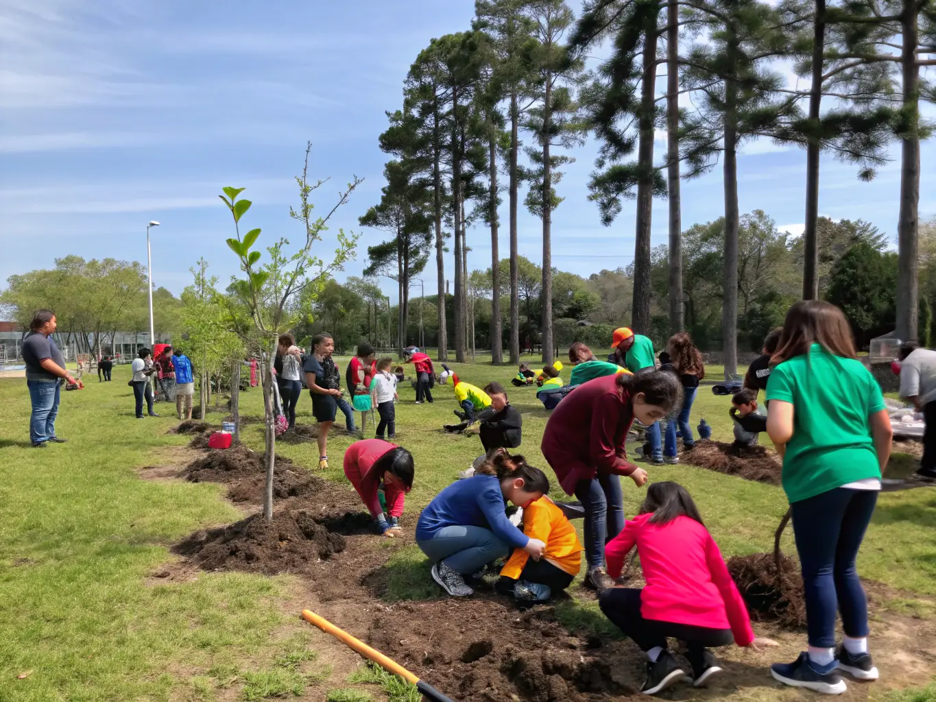 A group of community members and children participating in an outdoor environmental workshop.